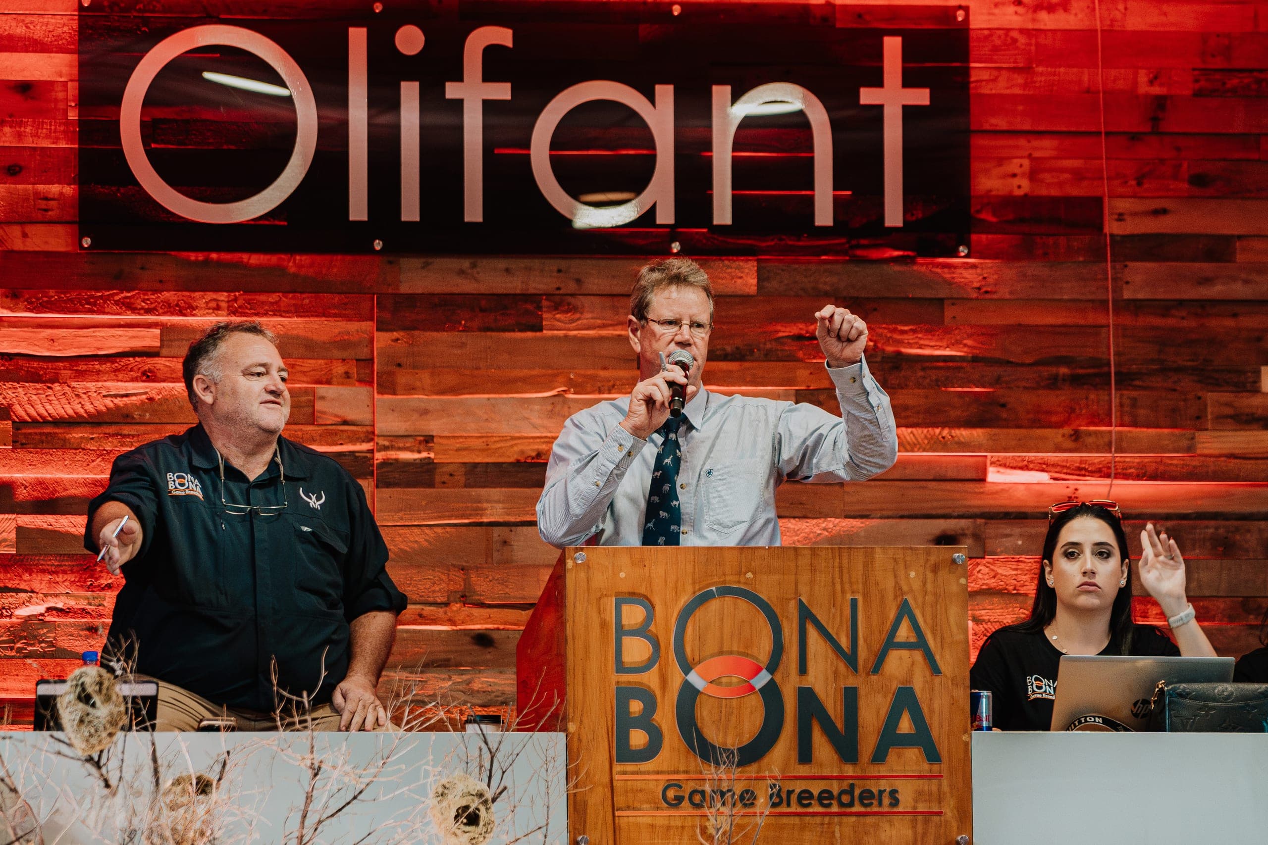 The auctioneers at the podium on the stage of a Platinum Auction
