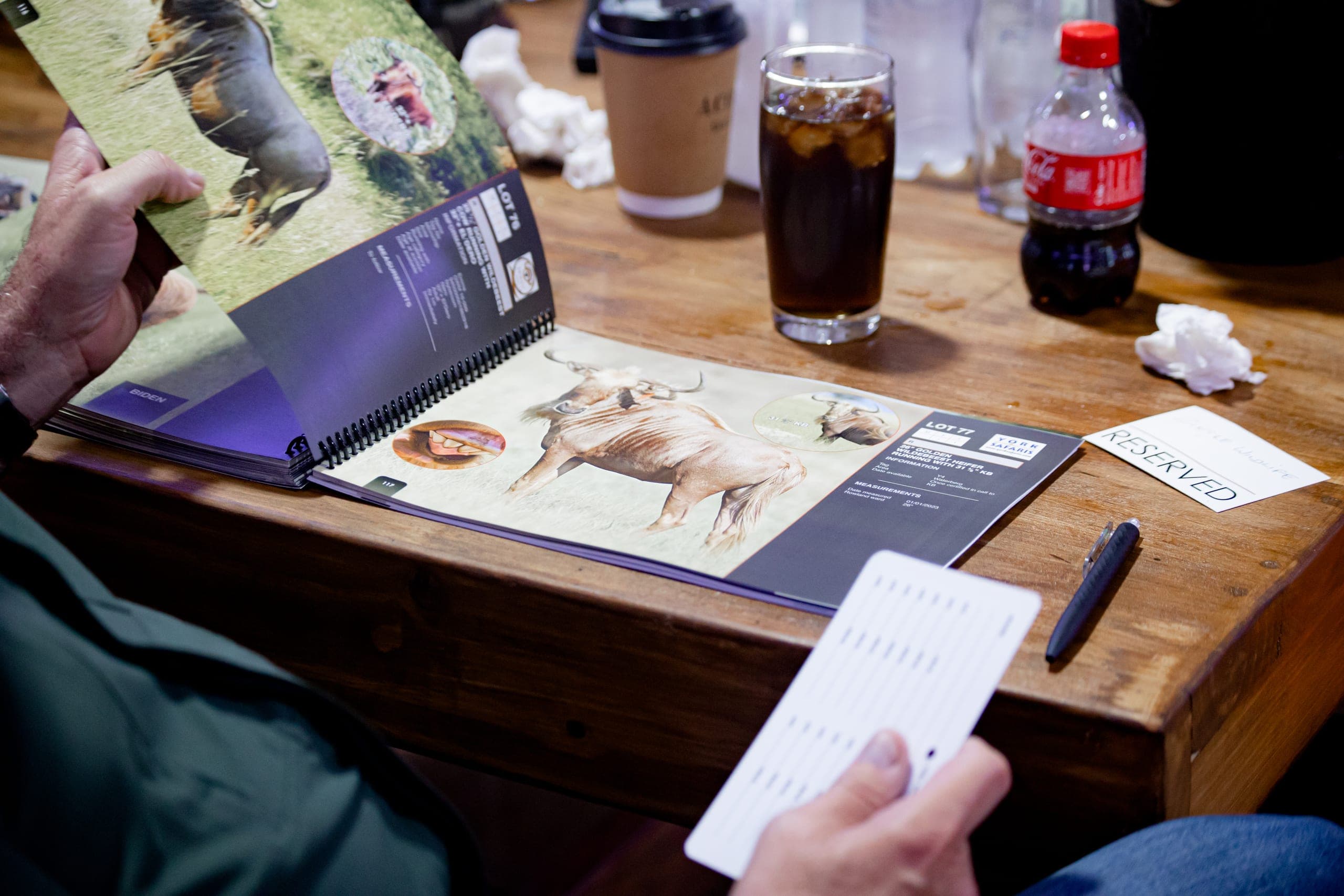 A buyer's open catalogue and bidding card on a table at a Platinum Auction
