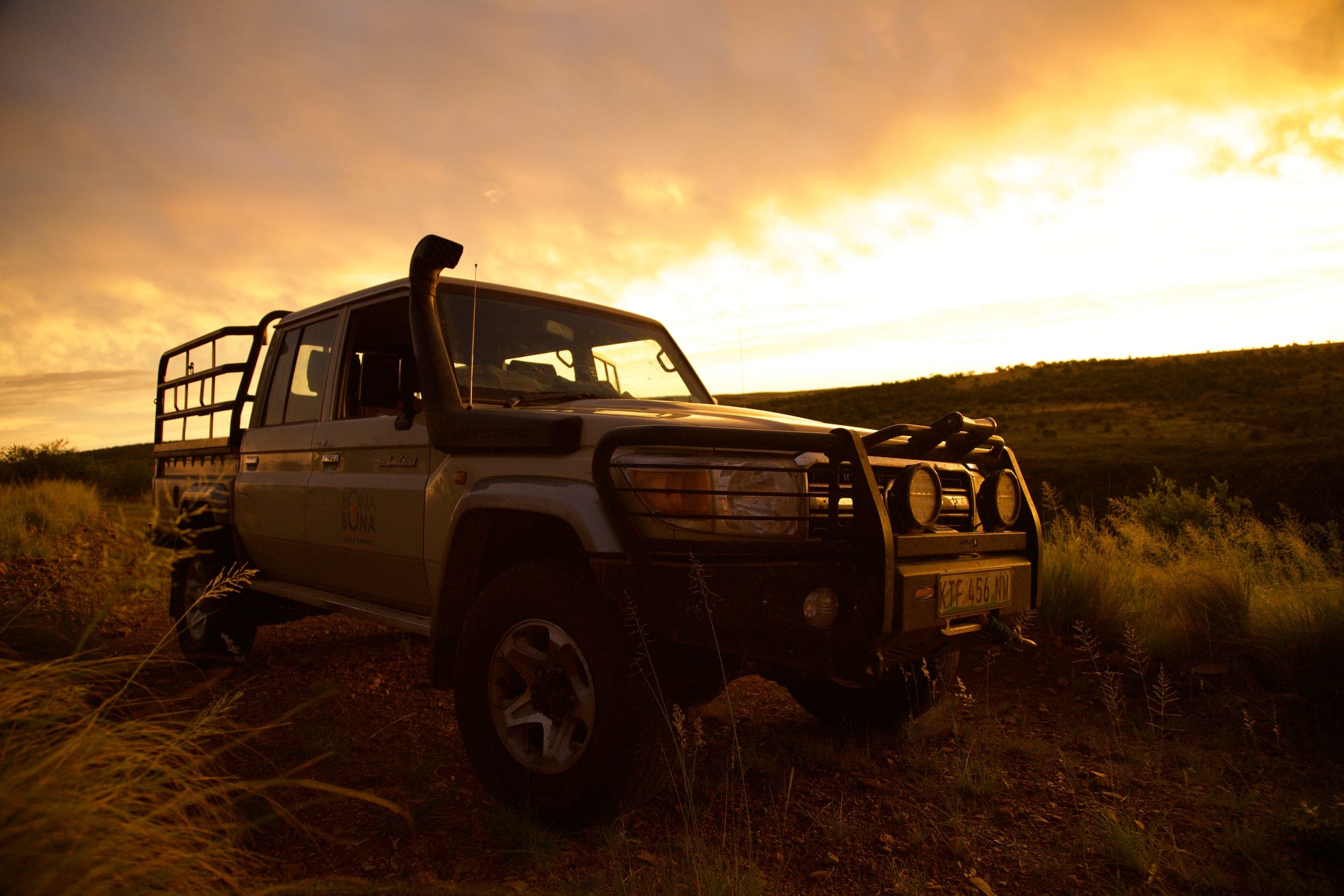 A game vehicle on a ridge at sunset