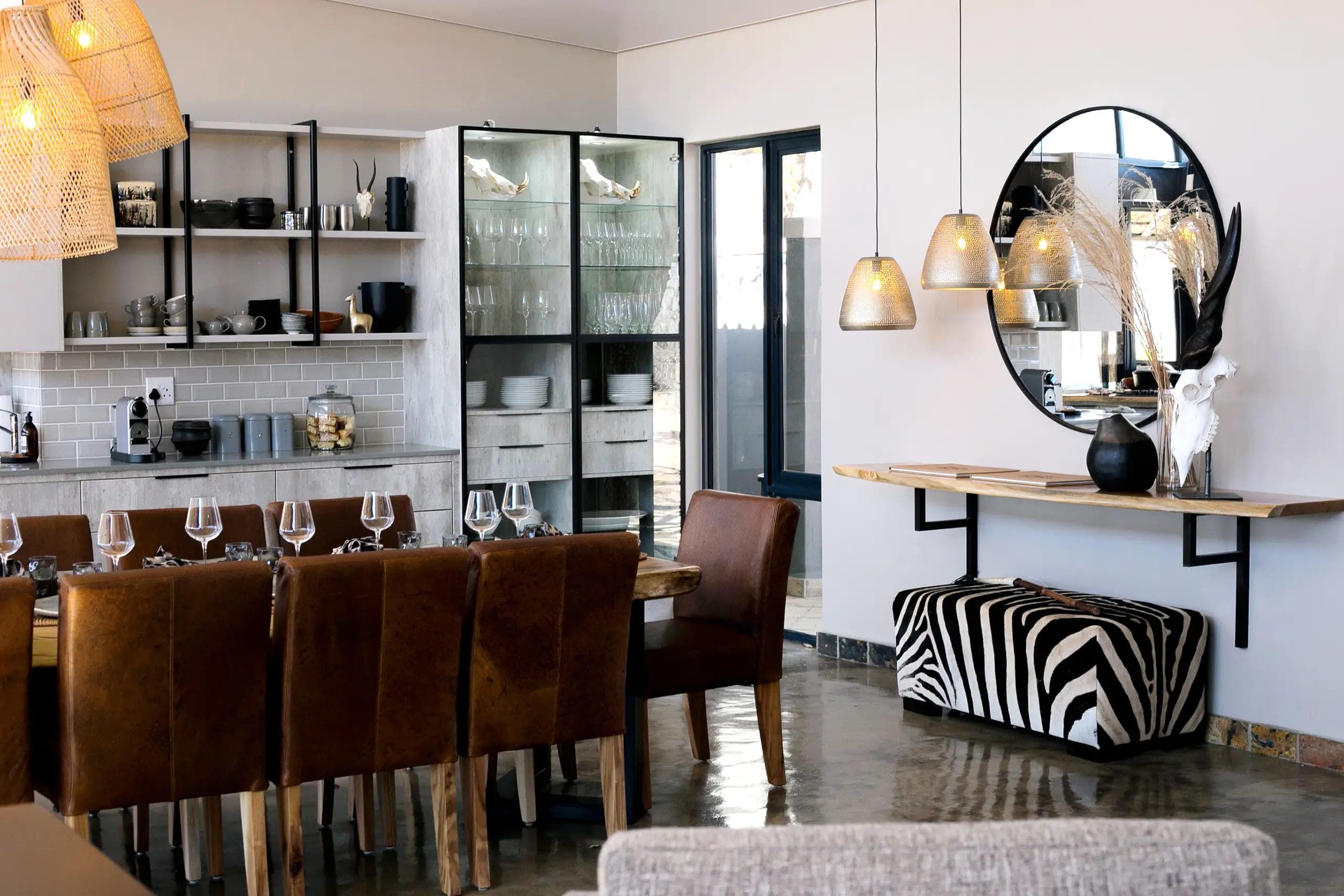 The lodge's dining room, with wooden chairs, a zebra-print bench and pendant lights